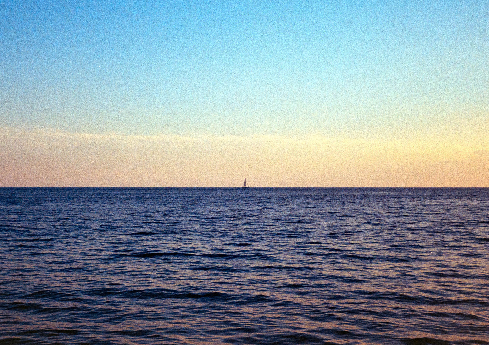 夕暮れの海と帆船